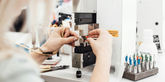 persoon die op een machine experimenteert met de toepassing van kunststoffen